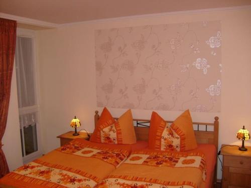格拉尔-米里茨Haus Bucheneck的一间卧室配有两张带橙色枕头的床