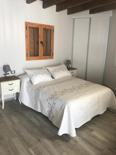 法塔加加那利伊利莎酒店的卧室配有白色的床,铺有木地板