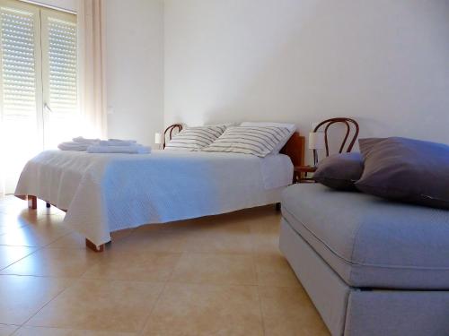 孔韦尔萨诺Delle Forche的一间卧室配有两张床和一张搁脚凳