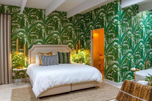 比勒陀利亚Bly B&B的一间卧室配有一张带热带壁纸的床