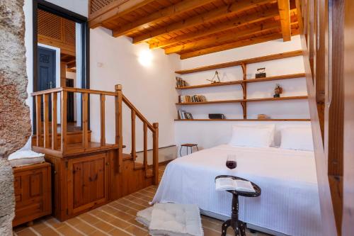 罗德镇Belvedere Medieval Villa的卧室配有白色的床和楼梯。