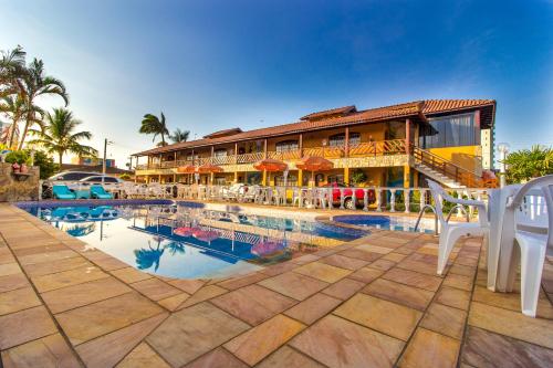 卡拉瓜塔图巴迎宾天堂酒店的一个带椅子的游泳池和一座建筑的度假胜地