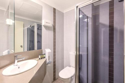 堪培拉Garden City Hotel, Best Western Signature Collection的浴室配有卫生间、盥洗盆和淋浴。