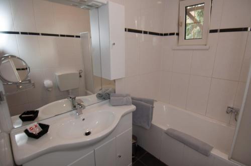 Deutsch Altenburg施特克尔餐厅酒店的白色的浴室设有水槽和浴缸。