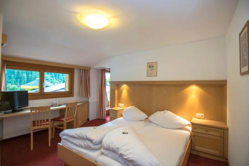 迈尔霍芬裴森里贾纳酒店的酒店客房设有一张大床和一张书桌。