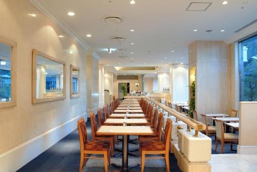 成田成田捷得威大飯店的餐厅里长长的桌子和椅子