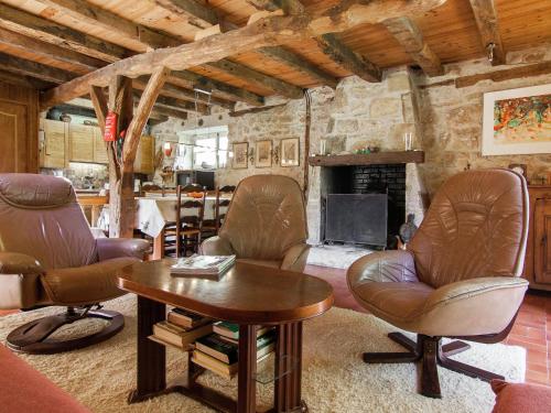 Saint-CybranetFarmhouse in Saint Cybranet with Private Garden的客厅配有真皮座椅和壁炉