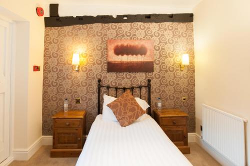 纽伯里Bacon Arms, Newbury的一间卧室配有床和2个床头柜