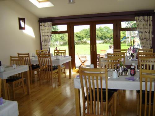 阿斯隆阿维纳之家住宿加早餐旅馆的一间设有白色桌椅和窗户的用餐室