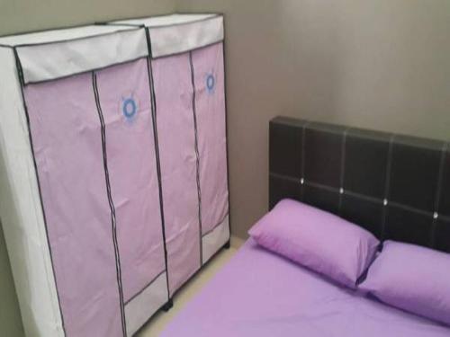 马六甲塔曼海岬西夏度假屋的客房内的粉红色婴儿床和紫色枕头