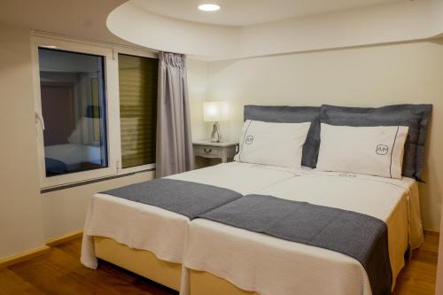 丰沙尔Apartments Madeira City Center的一间卧室设有一张大床和一个窗户。