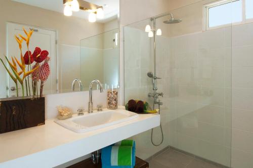 塔马林多The Breeze Hotel & Villas的白色的浴室设有水槽和淋浴。