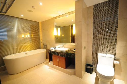 成都空港建国饭店(成都双流国际机场店)的带浴缸、卫生间和盥洗盆的浴室