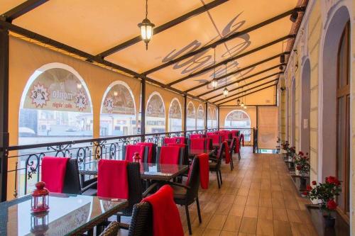 日利纳柏罗姆宫酒店的用餐室配有桌子和红色椅子
