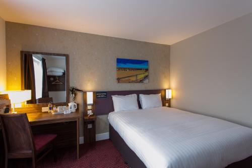 拉内利Sessile Oak, Llanelli by Marston's Inns的酒店客房带一张床铺、一张书桌和一间卧室