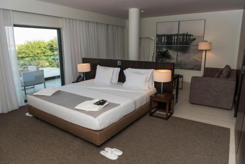 普拉亚裴罗拉酒店的酒店客房设有一张大床和一张沙发。
