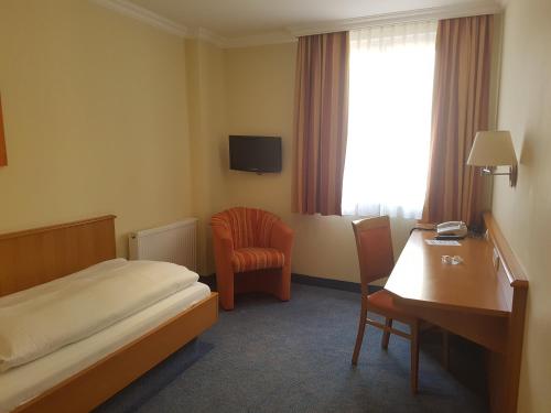 纽伦堡加尔尼凯穆尔酒店的酒店客房配有一张床、一张桌子和一把椅子。