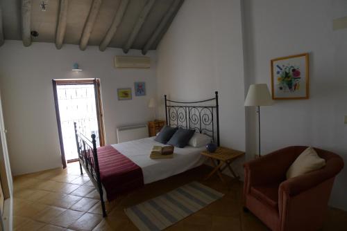 隆达萨尔瓦蒂拉旅馆 的卧室配有床、椅子和窗户。