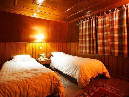KongdeMountain Lodges of Nepal - Kongde的卧室设有2张床和木镶板