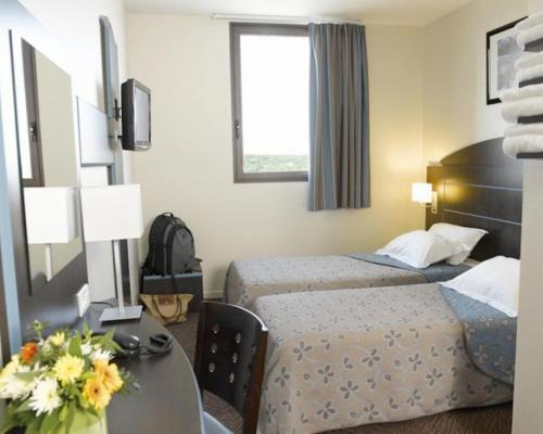 布朗斯雅嘉娜市阿尔比盖亚克酒店的酒店客房设有两张床和一张桌子。