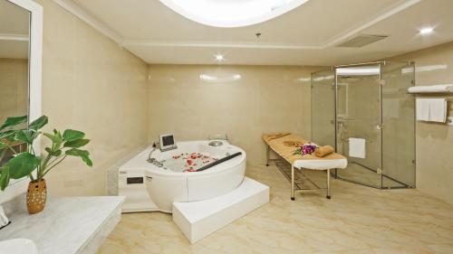 木州县蒙坦假日莫绍酒店的带浴缸和玻璃淋浴间的浴室。