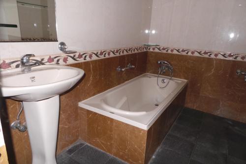 科泽科德斯潘酒店的浴室配有盥洗盆和浴缸。