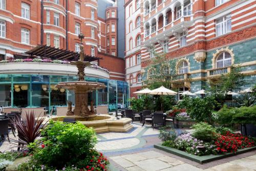 伦敦泰姬51白金汉门套房及公寓酒店的庭院设有喷泉、椅子和建筑