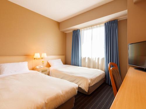秋田秋田竿灯大街珍珠城市饭店的酒店客房设有两张床和电视。
