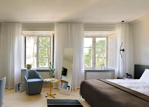 斯德哥尔摩Hotel Skeppsholmen, Stockholm, a Member of Design Hotels的一间卧室配有一张床、一把椅子和窗户。