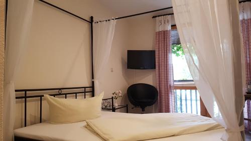 林巴-奥贝尔夫罗纳Schneiderlein Hotel的一间卧室配有一张床,窗户上配有电视