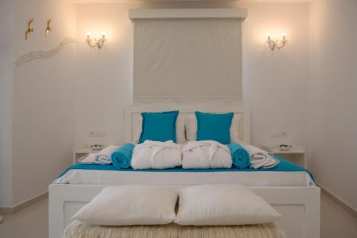 卡拉马基Aristodimos Luxury Suite的一间卧室配有一张带蓝色和白色枕头的床