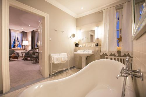 特里尔钟声浪漫酒店的白色的浴室设有浴缸和水槽。