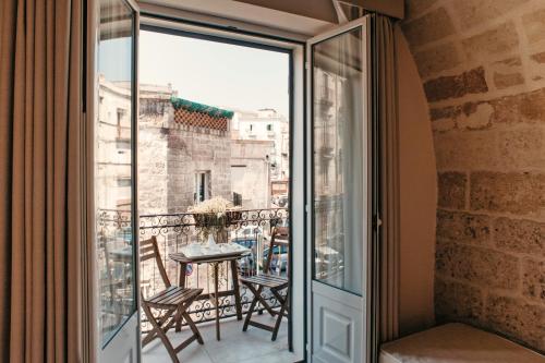 塔兰托Hotel L'Arcangelo - Boutique Hotel的客房设有带桌椅的阳台。
