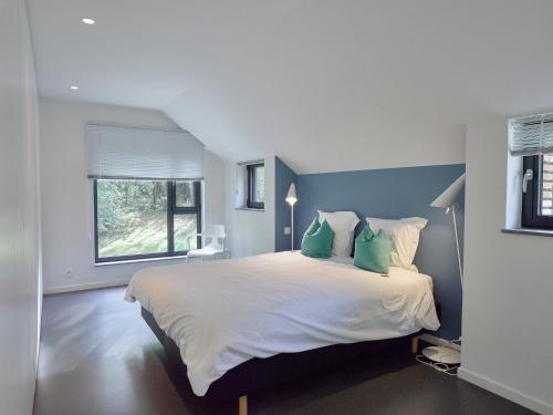 雅莱拉斯塔特度假屋的一间卧室配有一张带绿色枕头的大床