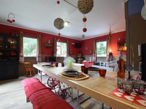 胡法利兹Chalet in a green and peaceful environment的客厅设有木桌和红色墙壁。