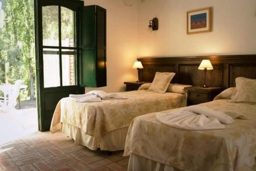 圣奥古斯汀镇芬卡拉美迪露娜酒店的酒店客房设有两张床和窗户。