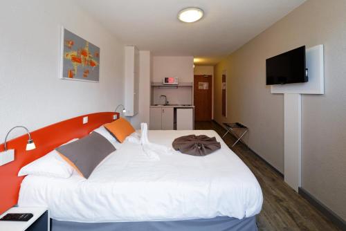 斯特拉斯堡斯特拉斯堡中心城市公寓式酒店的一间卧室配有一张白色大床和橙色床头板