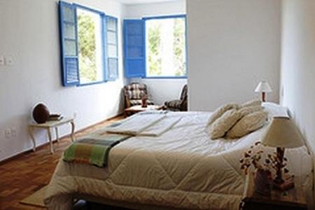 伊塔比里图Hotel Fazenda Caco de Cuia的一间卧室设有一张大床和两个窗户。