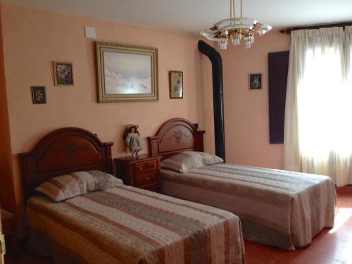 Torres de AlbarracínEncanto de Aragón的一间卧室配有两张床和吊灯。
