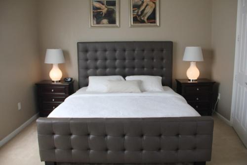 奥兰多Cayview Condo #231543的一间卧室配有一张大床,桌子上放着两盏灯