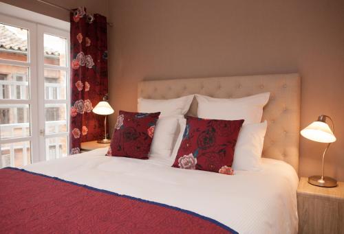 阿尔比L'appart du Cloitre的卧室配有带红色枕头的白色床