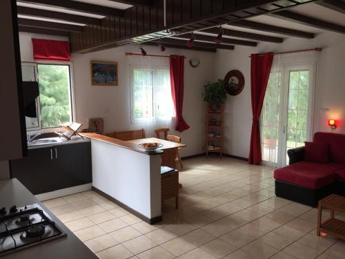 萨拉济马雷边游客度假屋的一间厨房和一间带红色沙发的客厅