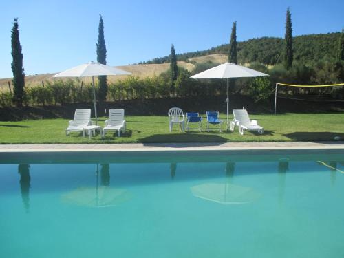 萨尔泰阿诺Agriturismo Stigliano的一组椅子和遮阳伞,位于游泳池旁