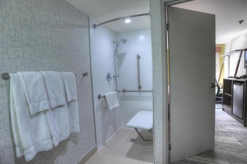米西索加多伦多机场西智选假日酒店的带淋浴和白色毛巾的浴室