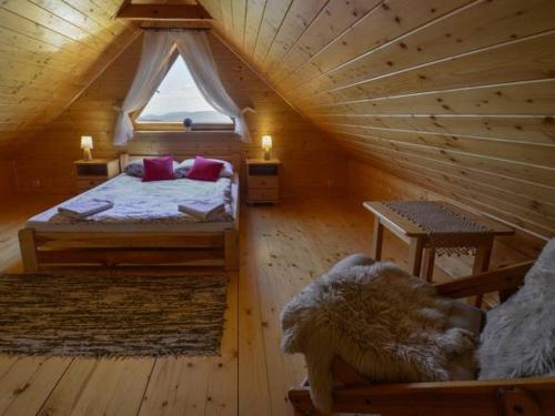 扎沃亚Domek drewniany simonka zawoja的小木屋内的卧室,配有床和窗户