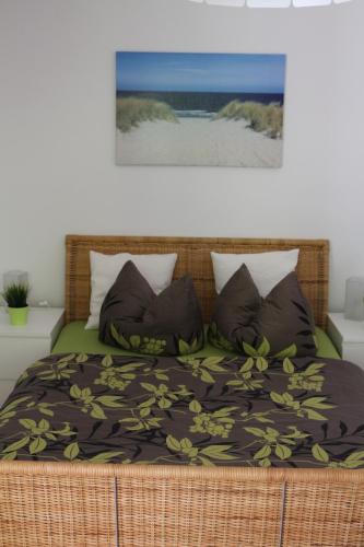 奥斯特巴特宁哈根Ferienwohnung Nienhagen的一间卧室配有一张带毯子和枕头的床。