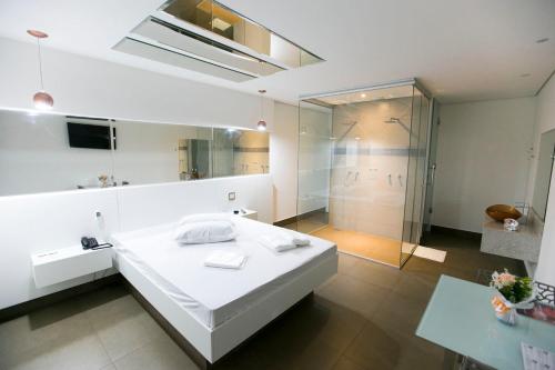 塞蒂拉瓜斯Hauss Excellence Motel的配有白色床和淋浴的浴室