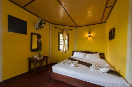 拜县拜县乡村酒店的卧室配有白色床和黄色墙