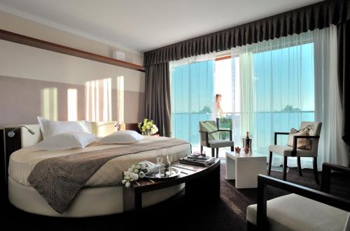 巴多利诺Aqualux Hotel Spa Suite & Terme的一间卧室设有一张大床和一个大窗户