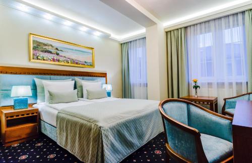 热舒夫格莱恩酒店的配有一张床和一把椅子的酒店客房